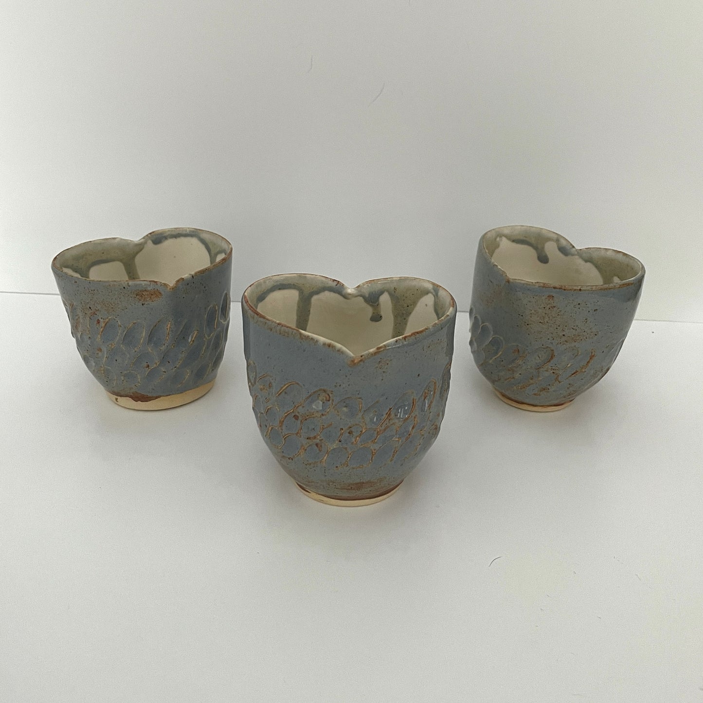 Carved light blue ceramic cups shaped like hearts