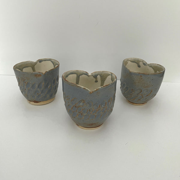 Carved light blue ceramic cups shaped like hearts