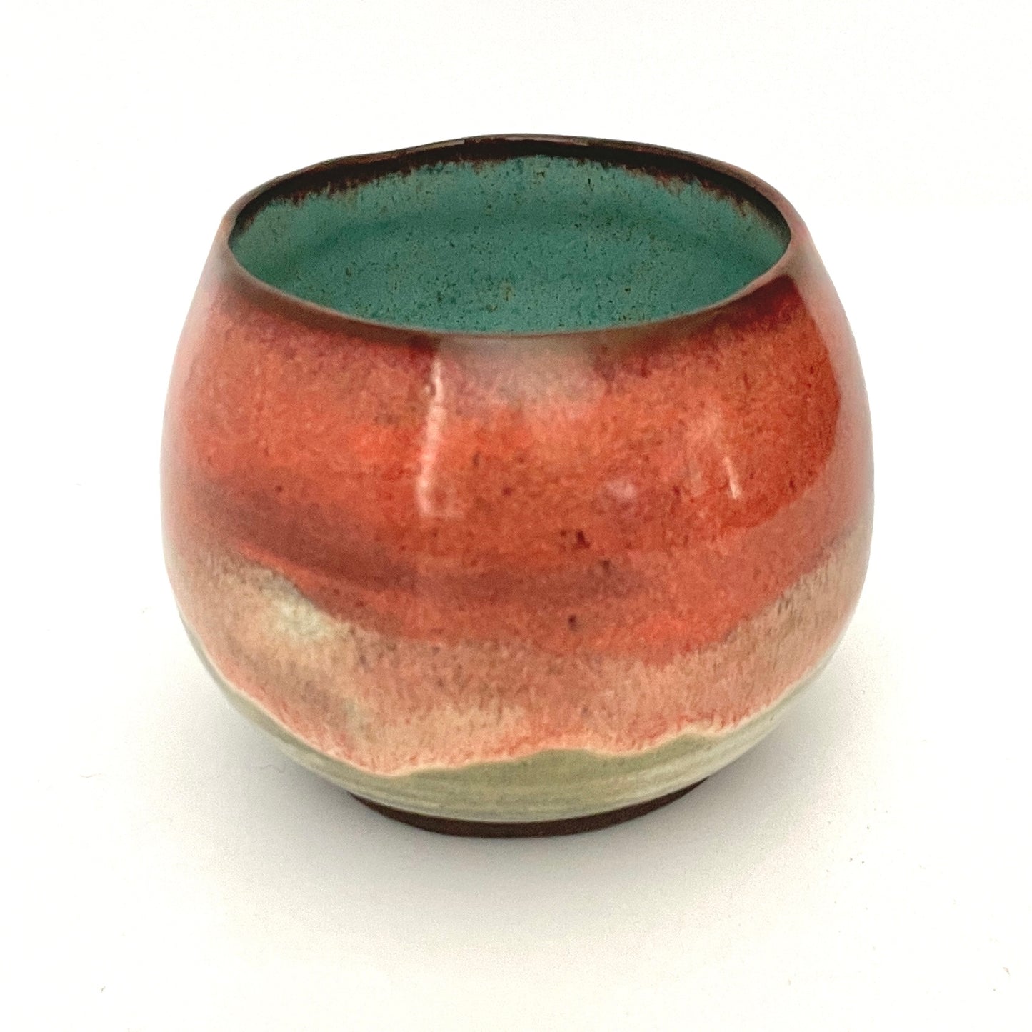Round red cup with Turquoise interior on Dark Clay