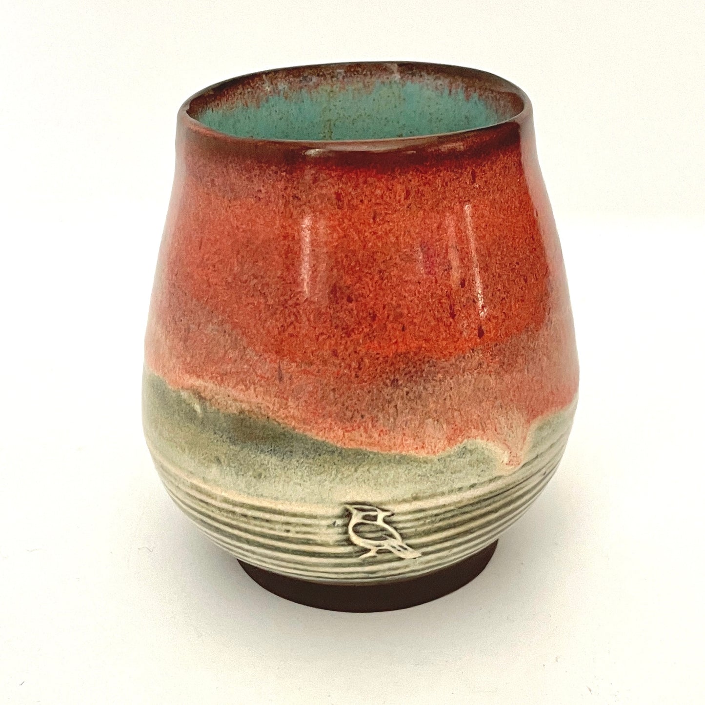 Red and Cream cup with Turquoise interior on Dark Clay