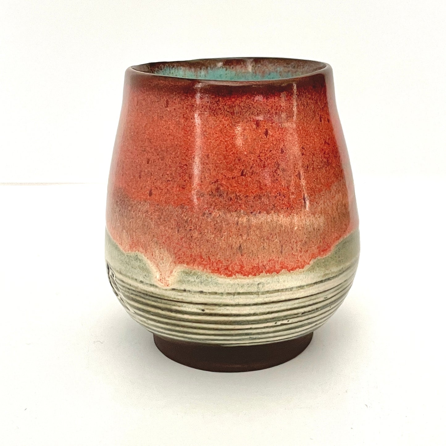 Red and Cream cup with Turquoise interior on Dark Clay