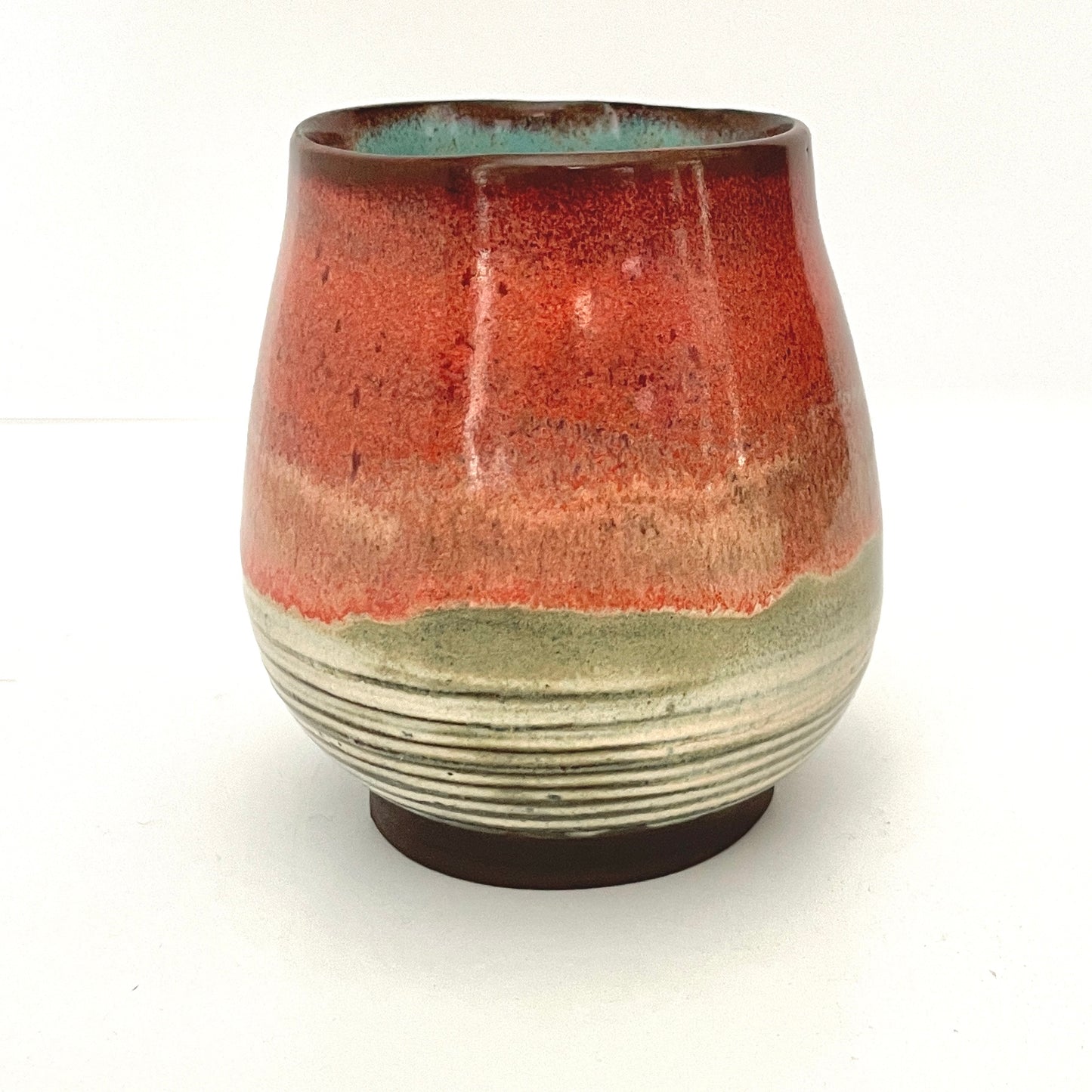 Red and Cream cup with Turquoise interior on Dark Clay