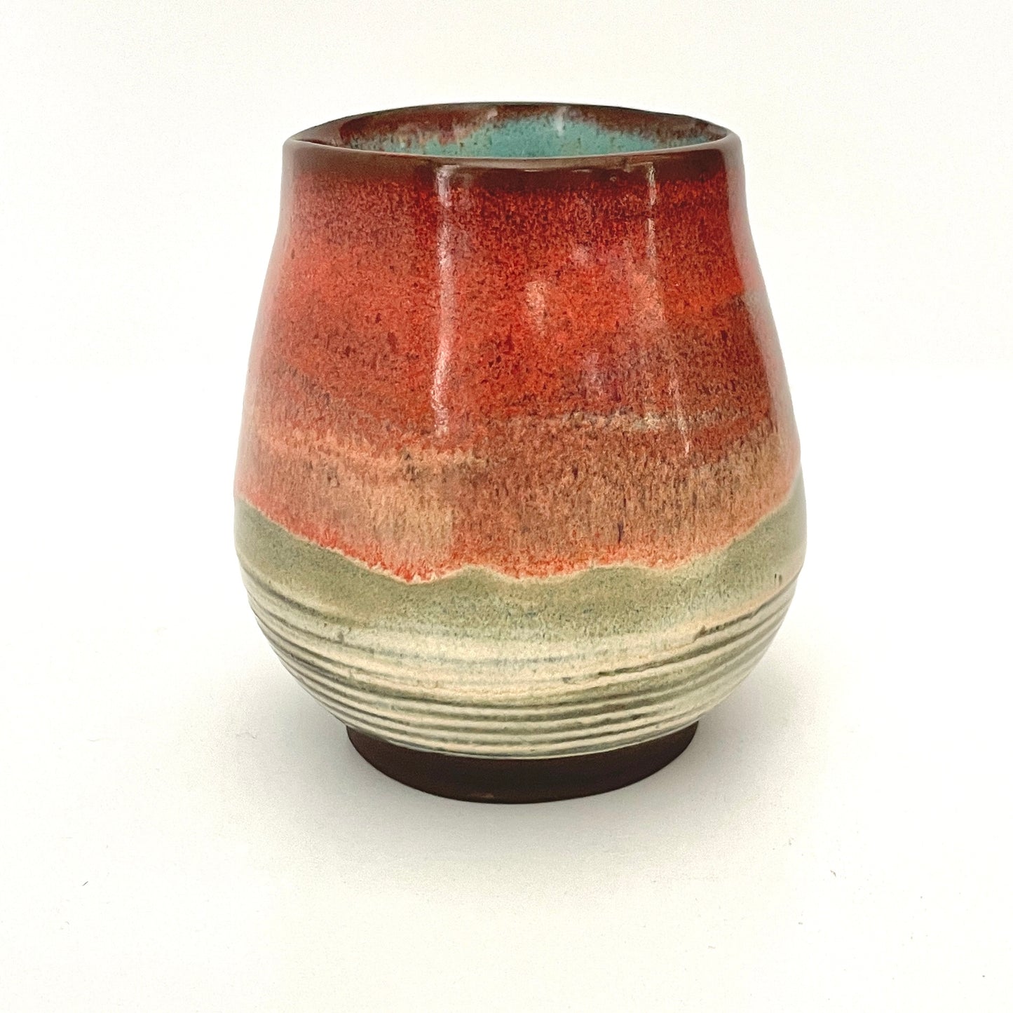 Red and Cream cup with Turquoise interior on Dark Clay