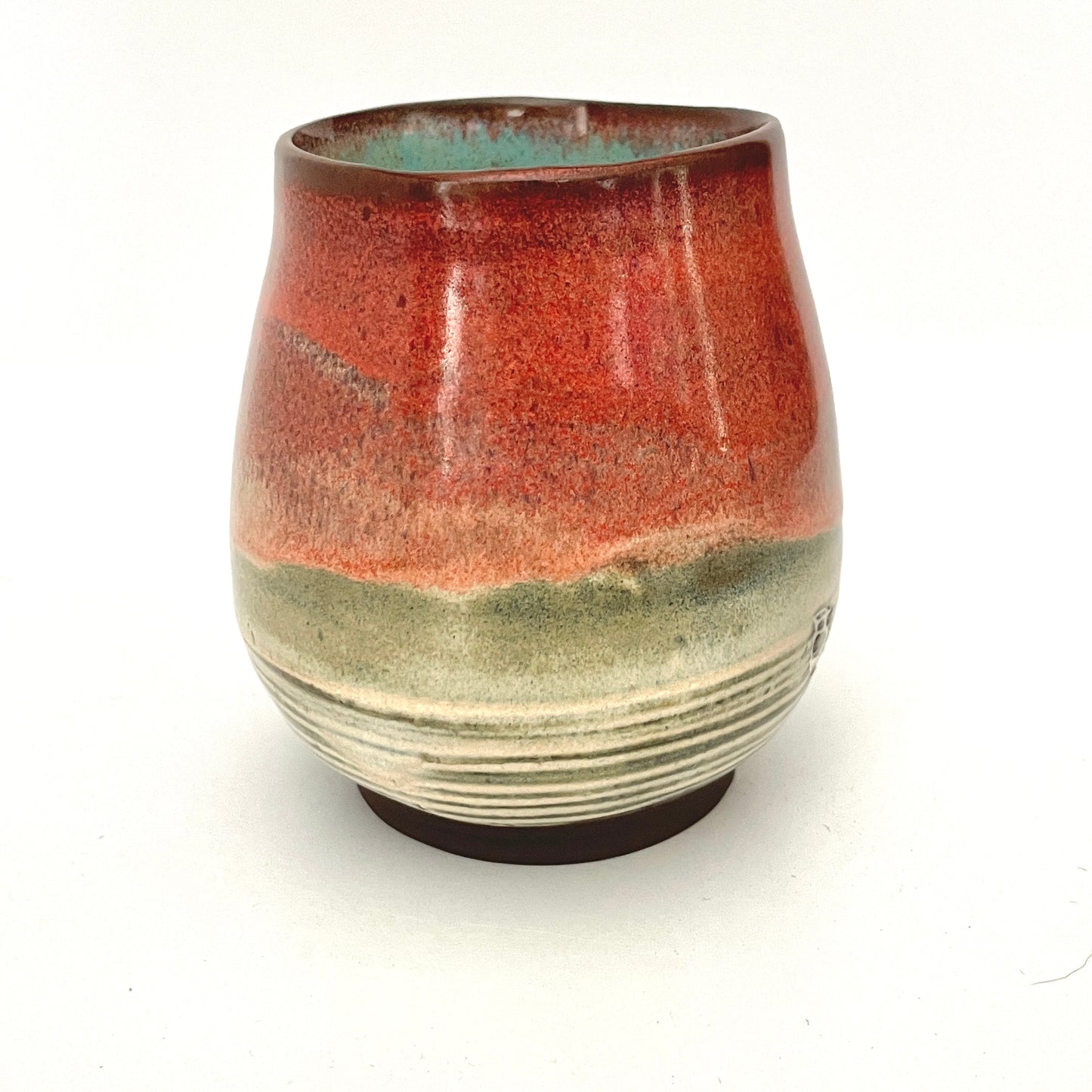 Red and Cream cup with Turquoise interior on Dark Clay