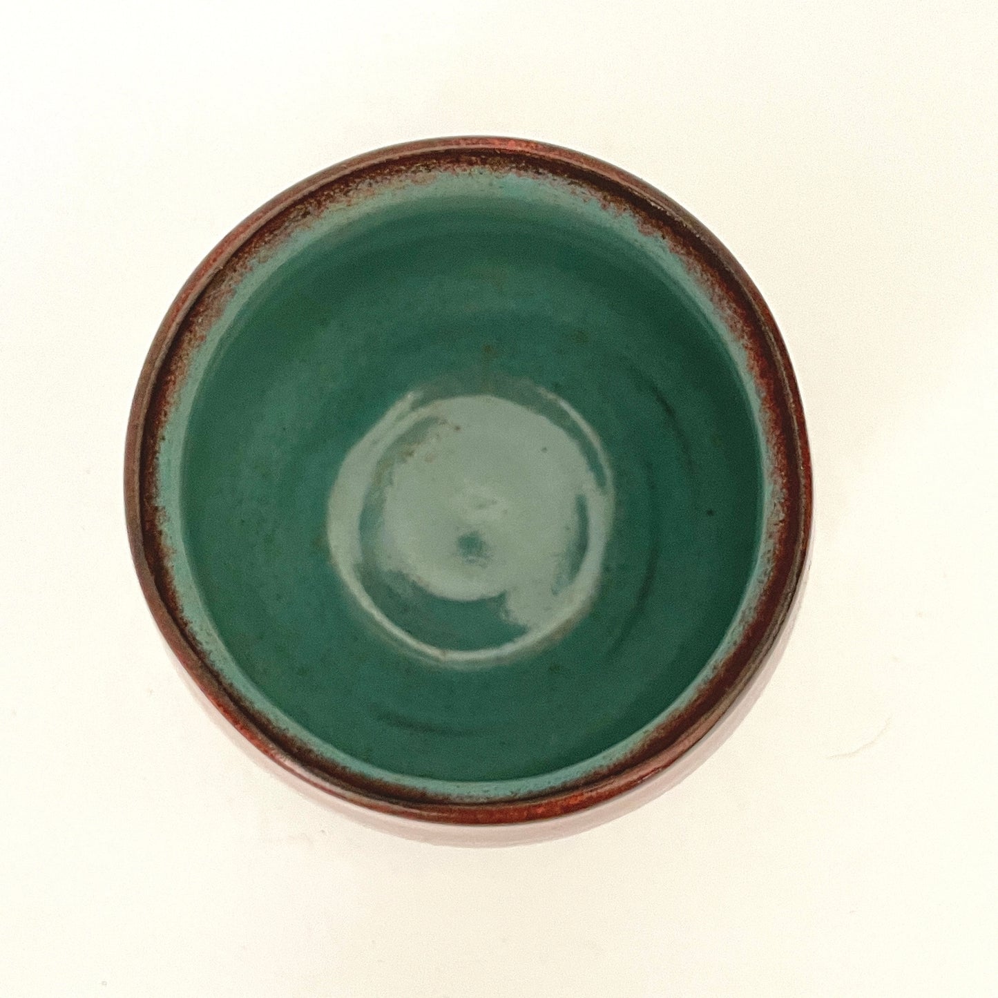 Red and Cream cup with Turquoise interior on Dark Clay