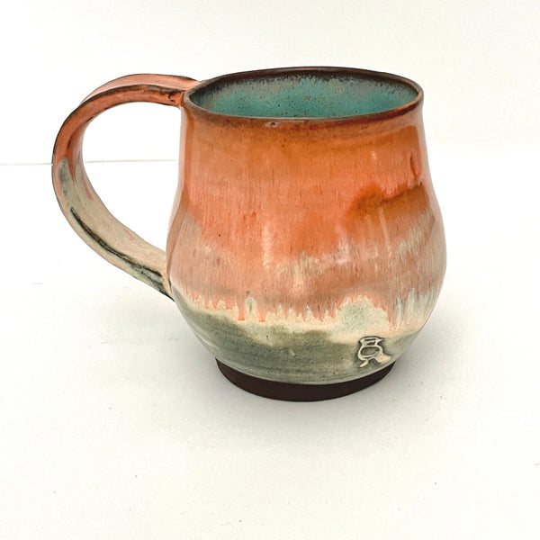 Orange and Cream mug with Turquoise interior on Dark Clay