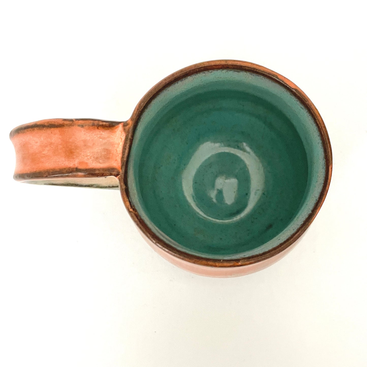 Orange and Cream mug with Turquoise interior on Dark Clay