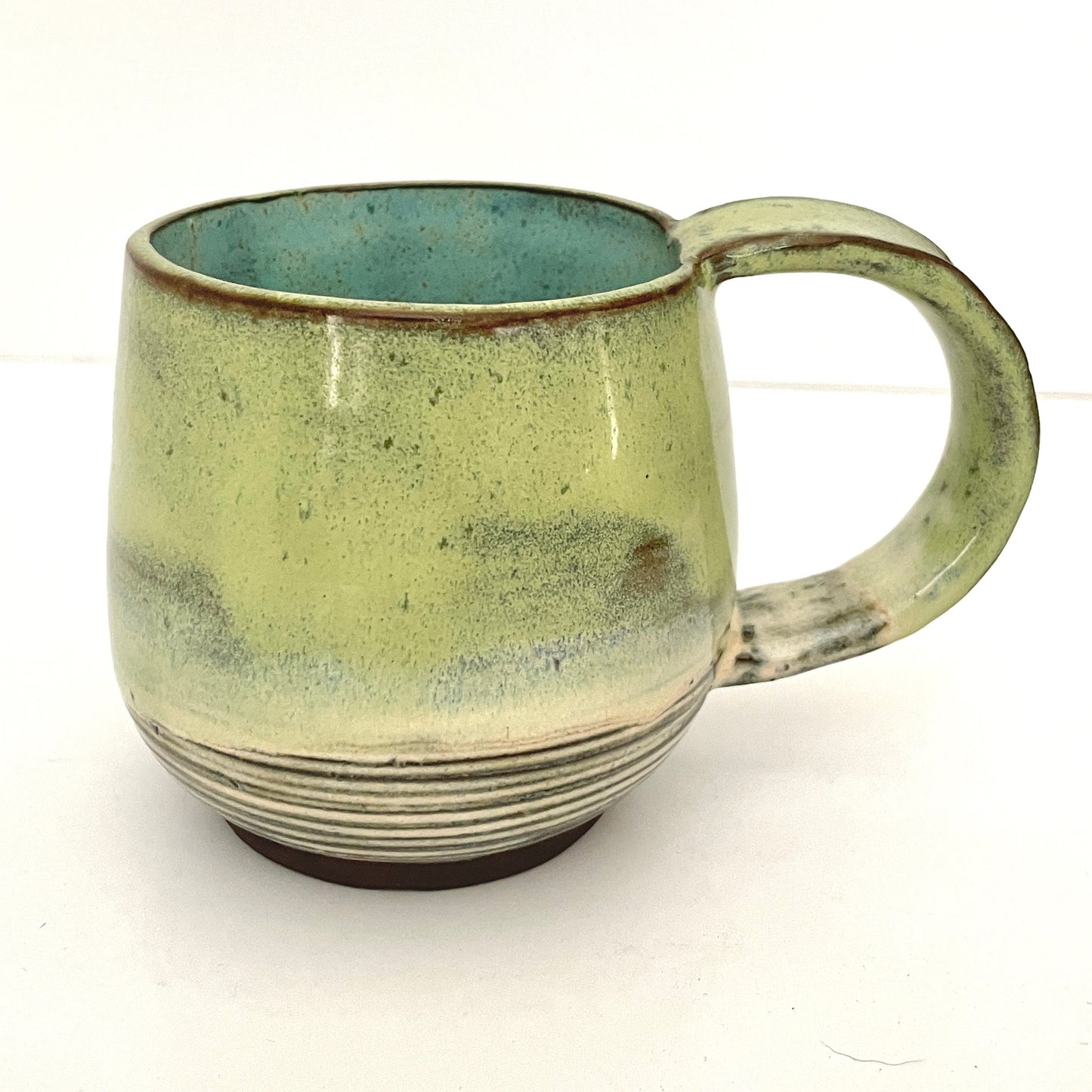 Green with Turquoise Interior Mug on Dark Clay