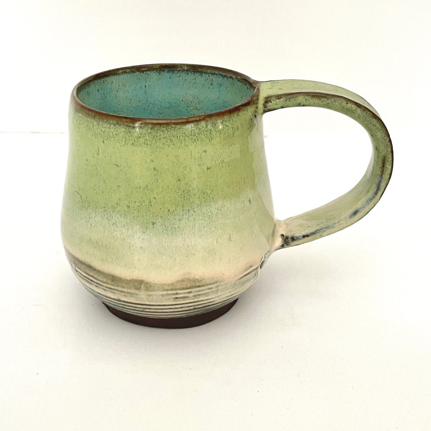 Green with Turquoise Interior Mug on Dark Clay